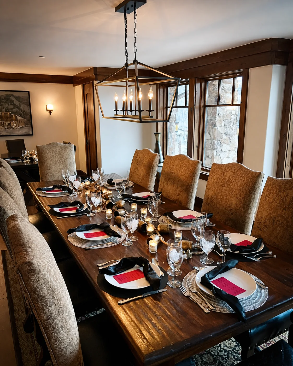 A formal private dining table set with candles, glassware, and place settings